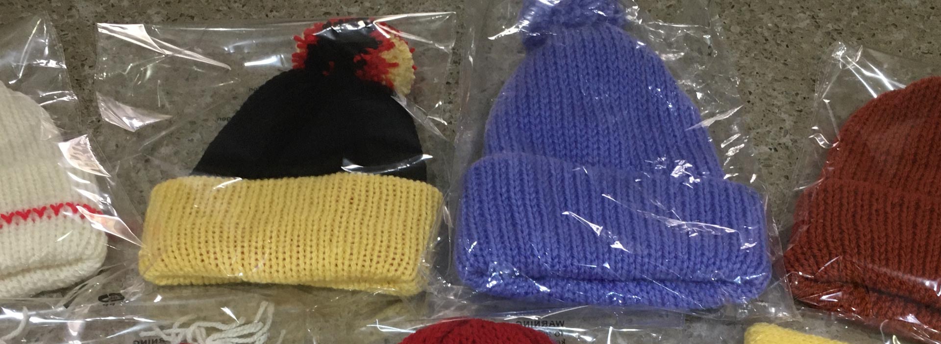 image of woollen hats, headbands, ear warmers and koozies sold by Shirley's Knitting Shop