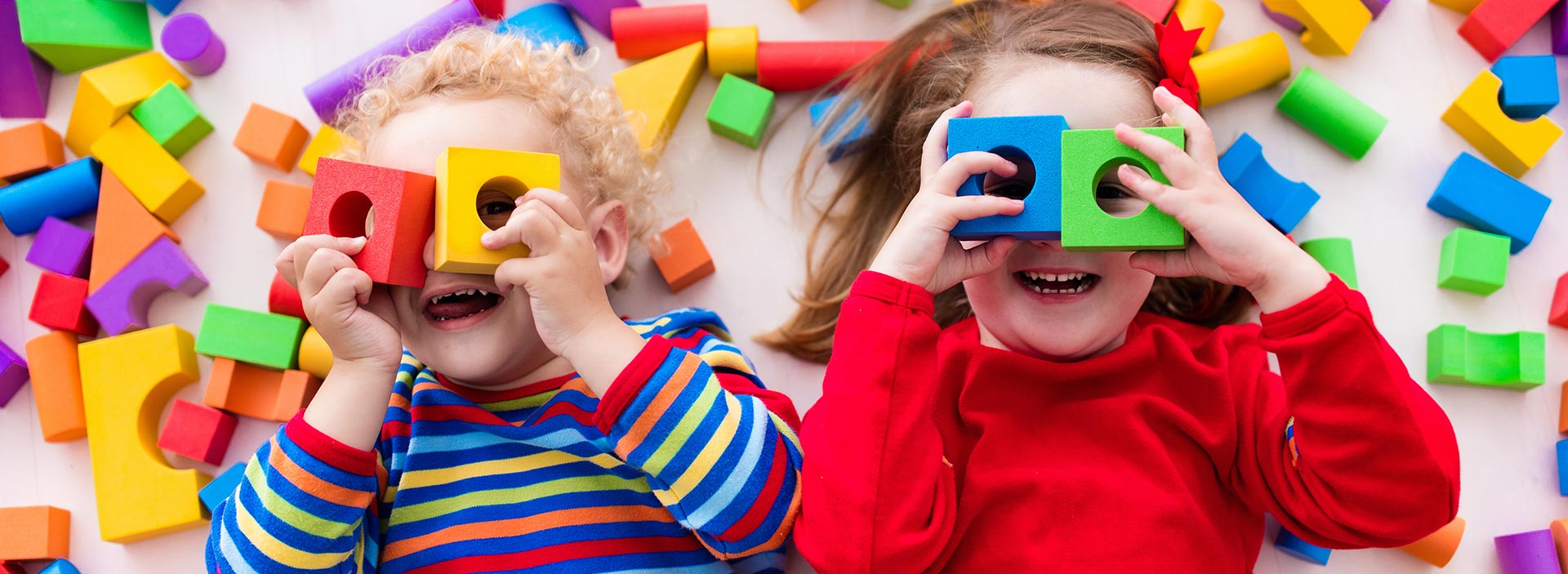 image showing two children playing with colourful sponge blocks